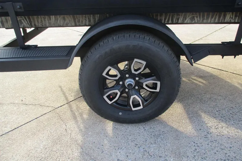 Slide: The Image of 2026 Tracker Grizzly 1650 T Prairie Wings Edition wheel on concrete surface. - 10