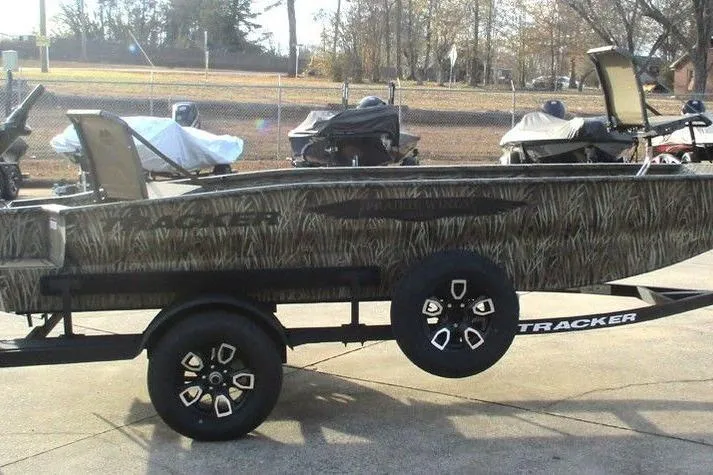 Slide: The Image of 2026 Tracker Grizzly 1650 T Prairie Wings Edition boat on trailer, camo design, parked outdoors. - 5