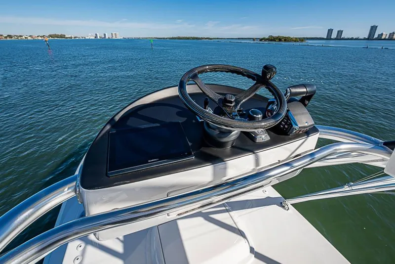 Slide: The Image of Helm of Sparks 46 boat, 2025 model, overlooking calm blue waters and distant cityscape. - 114