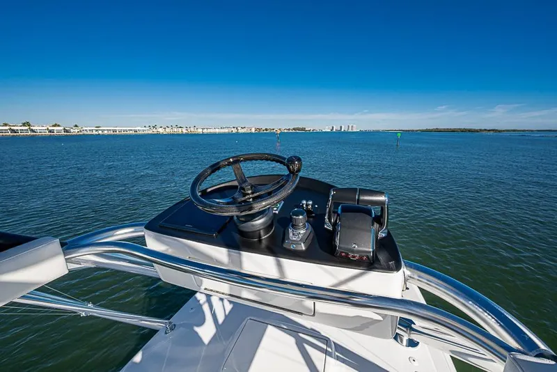 Slide: The Image of Helm of Sparks 46 boat, 2025 model, overlooking calm blue waters. - 116