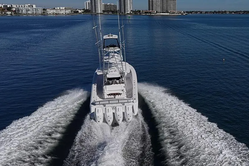 Slide: The Image of Sparks 46 boat cruising on water, 2025 model, with city skyline in background. - 17