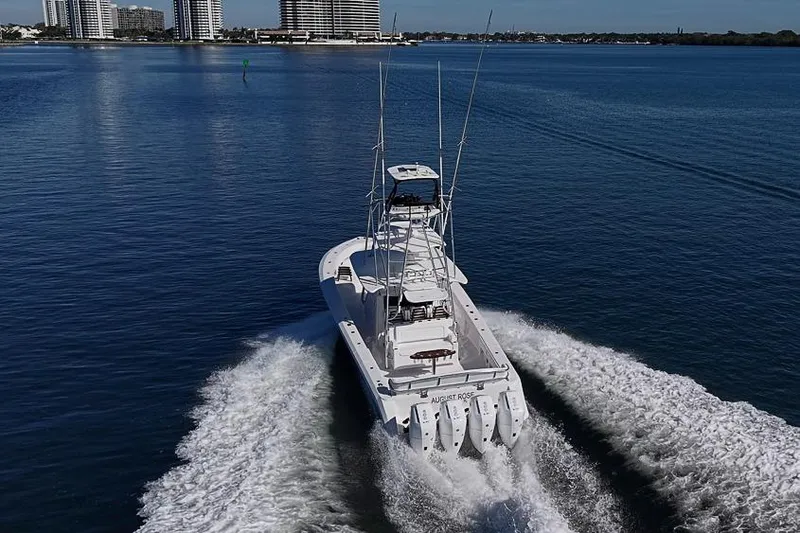 Slide: The Image of A 2025 Sparks 46 boat cruising on a calm waterway near city buildings. - 18