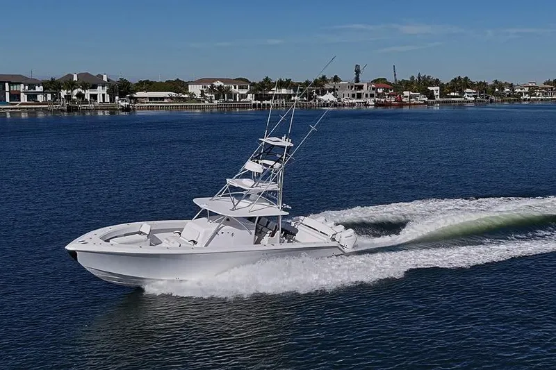 Slide: The Image of A 2025 Sparks 46 boat cruising on a calm blue waterway near waterfront homes. - 29