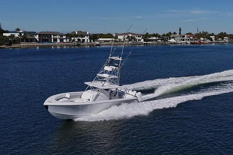 Slide: The Image of 2025 Sparks 46 boat cruising on a calm lake near waterfront homes. - 30