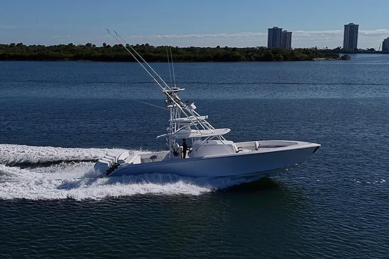 Slide: The Image of A sleek 2025 Sparks 46 yacht cruising on a calm blue sea near a cityscape. - 33