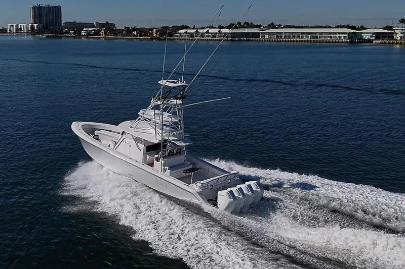 Slide: The Image of A 2025 Sparks 46 boat cruising on calm waters near a coastal city. - 36