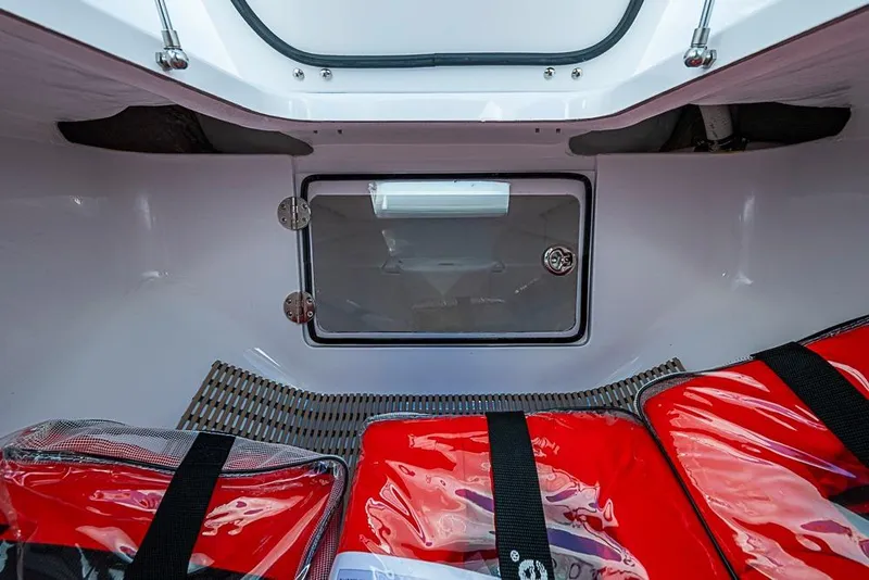 Slide: The Image of Interior of 2025 Sparks 46 boat with red life jackets and storage compartment. - 63