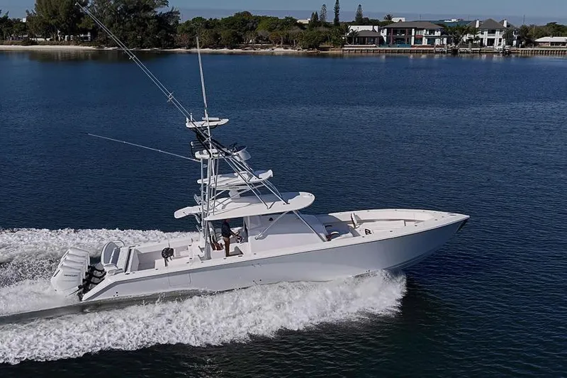 Slide: The Image of 2025 Sparks 46 boat cruising on a calm lake with scenic shoreline. - 9