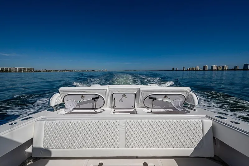 Slide: The Image of Sparks 46 boat cruising on open water, 2025 model, with city skyline in background. - 90