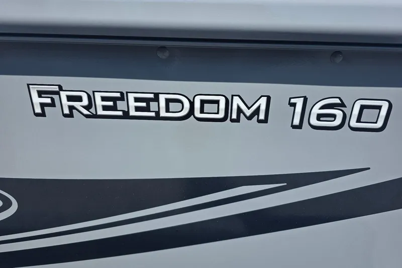 Slide: The Image of 2026 Smoker Craft Freedom 160 TL boat logo on gray surface. - 4