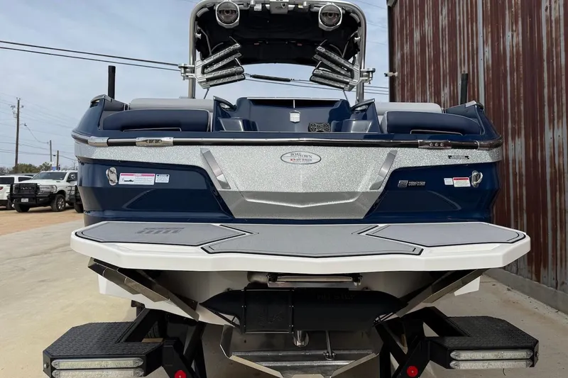 Slide: The Image of 2024 MasterCraft X24 boat, rear view, parked outdoors, showcasing sleek design and modern features. - 3