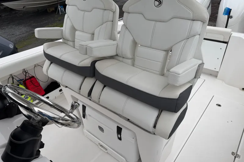 Slide: The Image of 2024 Edgewater 262CC boat interior with dual cushioned seats and steering wheel. - 21