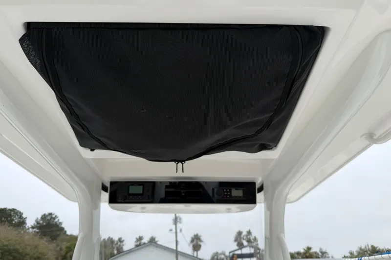 Slide: The Image of 2024 Edgewater 262CC boat interior with black storage compartment and control panel. - 24