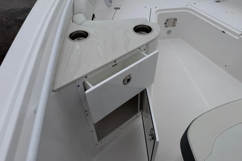 Slide: The Image of 2024 Edgewater 262CC boat interior with storage compartment and cup holders. - 26