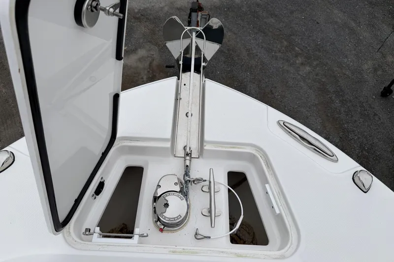 Slide: The Image of 2024 Edgewater 262CC boat anchor compartment with open hatch and visible winch system. - 28