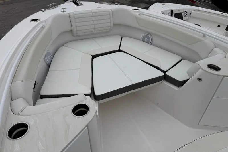 Slide: The Image of 2024 Edgewater 262CC boat interior with cushioned seating and cup holders. - 32