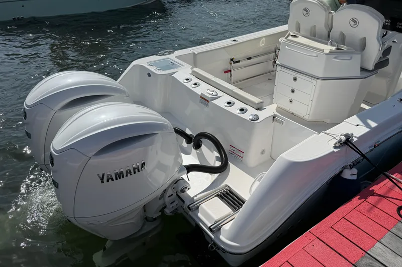 Slide: The Image of 2024 Edgewater 262CC boat with dual Yamaha outboard engines docked by the water. - 7