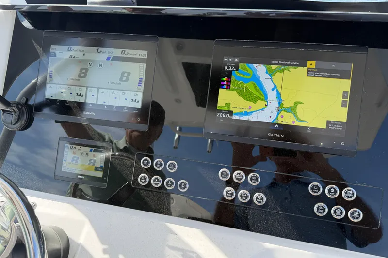 Slide: The Image of 2024 Edgewater 262CC boat dashboard with Garmin navigation displays and control buttons. - 8