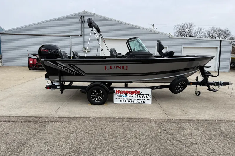 The Image of 2026 Lund 1875 Impact XS Sport boat on trailer at Hennepin Marine dealership. - 0