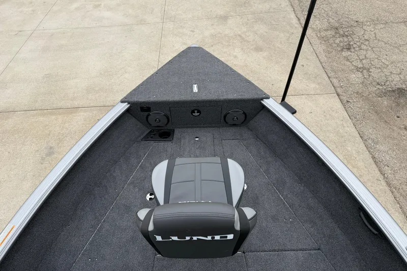Slide: The Image of 2026 Lund 1875 Impact XS Sport boat interior with gray seating and carpeted deck. - 11