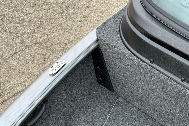 Slide: The Image of Interior detail of 2026 Lund 1875 Impact XS Sport boat, featuring carpeted finish and metal fittings. - 14