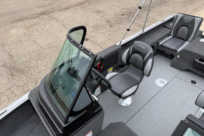 Slide: The Image of 2026 Lund 1875 Impact XS Sport boat interior with sleek seating and modern dashboard. - 16