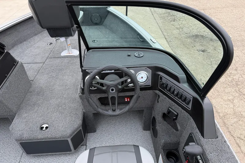 Slide: The Image of 2026 Lund 1875 Impact XS Sport boat interior with steering wheel and dashboard controls. - 22