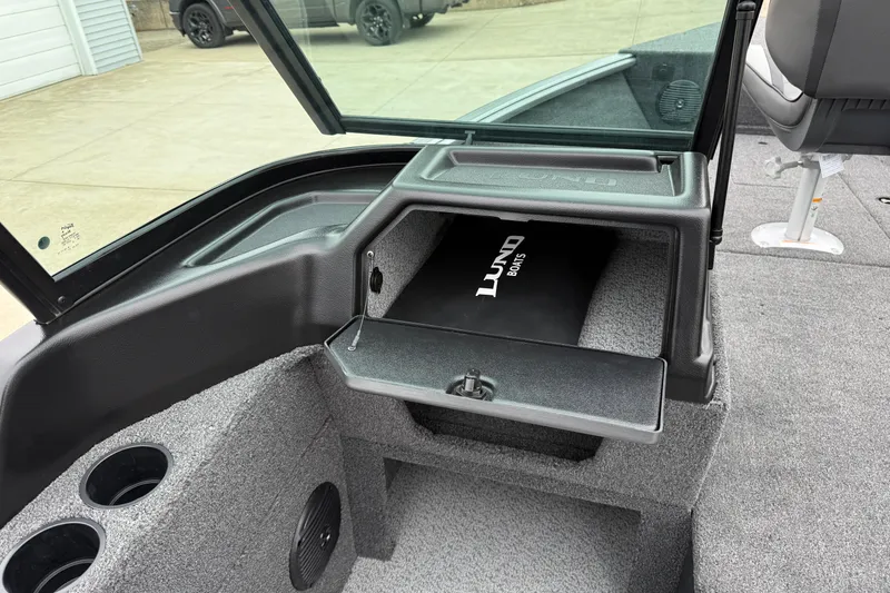 Slide: The Image of 2026 Lund 1875 Impact XS Sport boat interior with storage compartment and cup holders. - 28