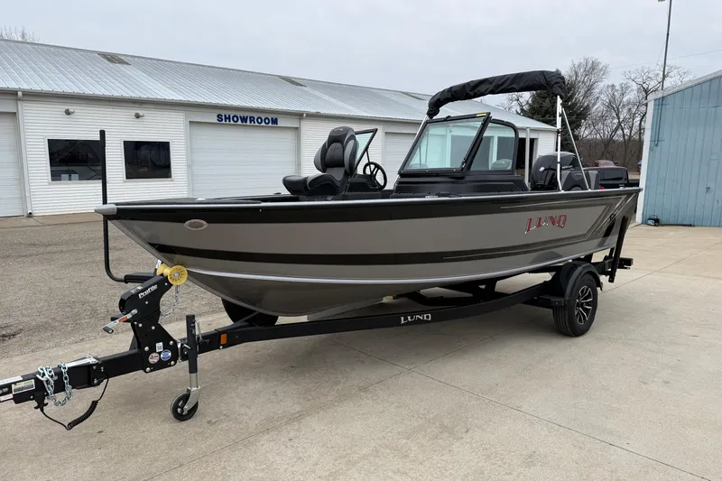 Slide: The Image of 2026 Lund 1875 Impact XS Sport boat on trailer outside showroom. - 3