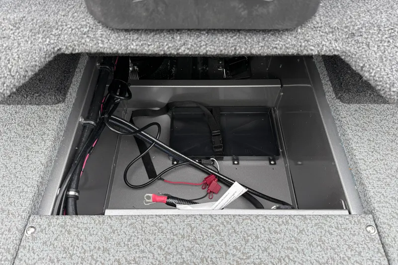 Slide: The Image of 2026 Lund 1875 Impact XS Sport boat storage compartment with wiring and straps. - 32
