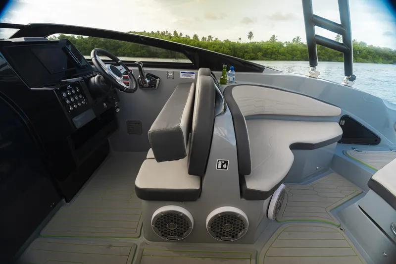 Slide: The Image of 2025 NX Boats NX260 interior with modern dashboard and seating, overlooking serene water and greenery. - 7