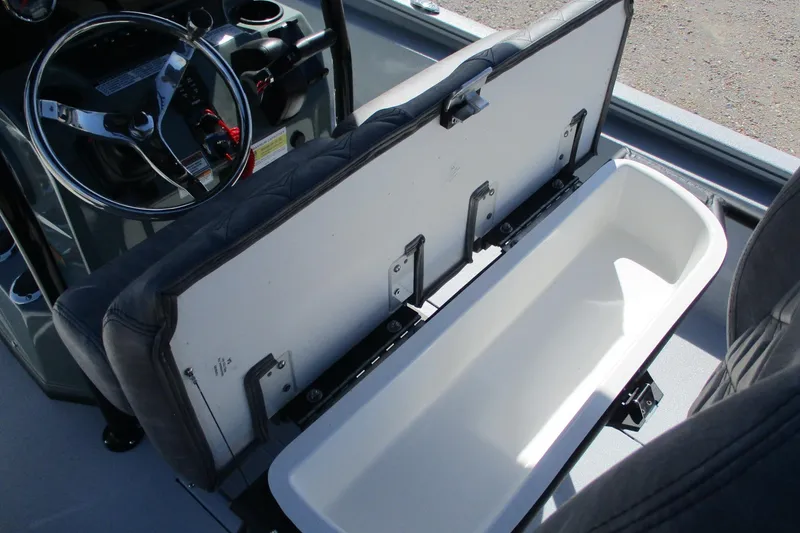Slide: The Image of Avid 23 Fusion 2026 boat interior with open storage compartment and steering wheel. - 23