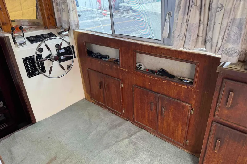 Slide: The Image of 1986 Henriques Yachts 35 Maine Coaster interior with steering wheel and wooden cabinetry. - 15