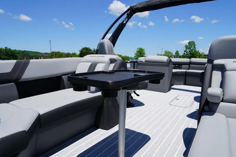 Slide: The Image of 2026 Berkshire 24 RFX CTS pontoon boat interior with gray seating and table, under blue sky. - 18