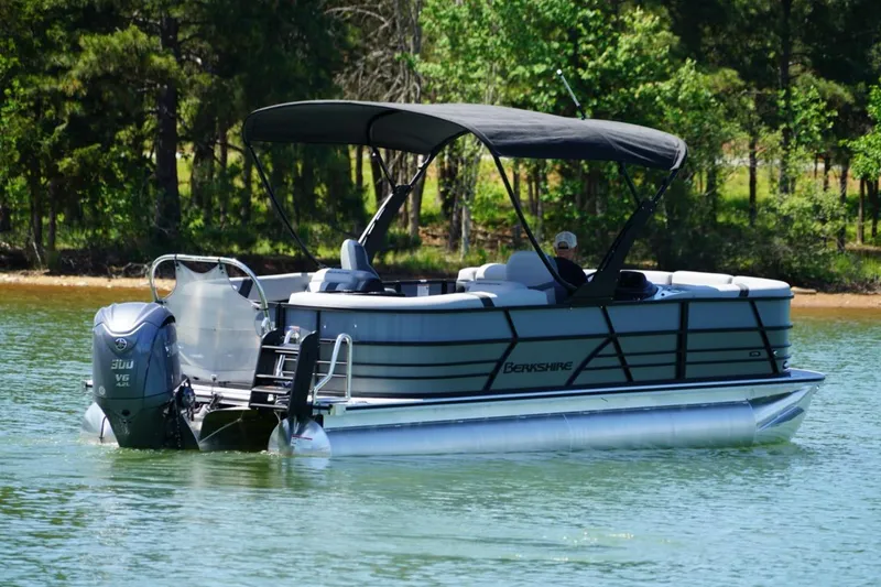 Slide: The Image of 2026 Berkshire 24 RFX CTS pontoon boat on a serene lake with lush greenery. - 19