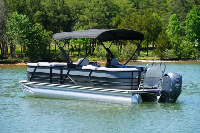 Slide: The Image of 2026 Berkshire 24 RFX CTS pontoon boat on a serene lake with lush greenery. - 20