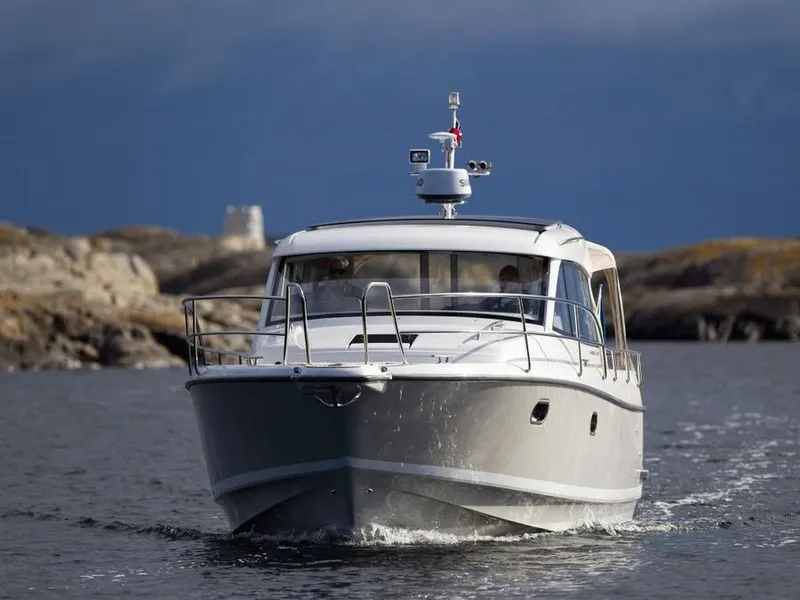 Slide: The Image of Nimbus 365 Coupe 2027 cruising on calm waters near rocky coastline. - 1