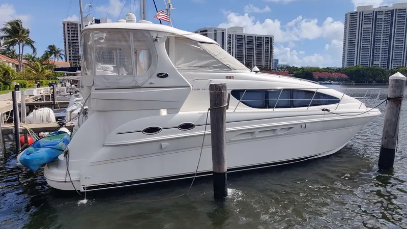 The Image of 2003 Sea Ray 390 Motor Yacht docked in a marina with cityscape background. - 1