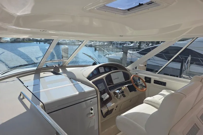 Slide: The Image of 2003 Sea Ray 390 Motor Yacht helm with modern navigation equipment and waterfront view. - 18