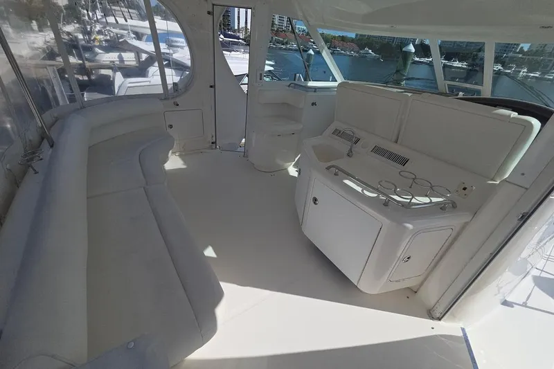 Slide: The Image of 2003 Sea Ray 390 Motor Yacht interior with white seating and kitchenette, docked at marina. - 21