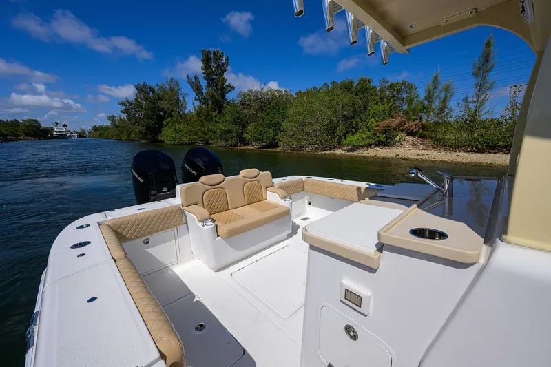 Slide: The Image of 2024 HCB 39 Speciale boat interior with seating and sink, cruising on a scenic waterway. - 18