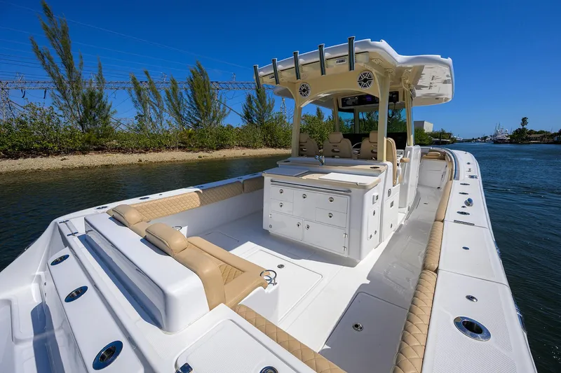Slide: The Image of 2024 HCB 39 Speciale boat with luxurious seating and storage, docked by a scenic waterway. - 19