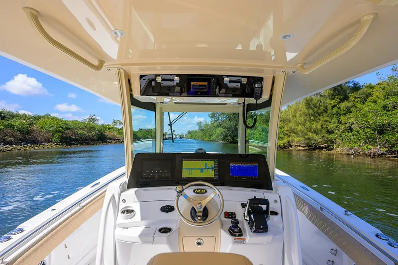 Slide: The Image of 2024 HCB 39 Speciale boat cockpit with advanced navigation system on a scenic waterway. - 44