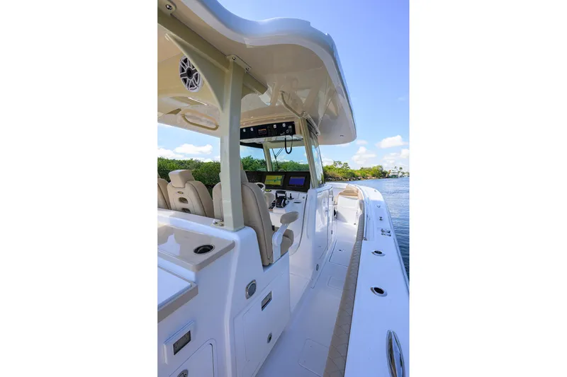 Slide: The Image of 2024 HCB 39 Speciale boat interior with modern helm and seating, cruising on a sunny day. - 48