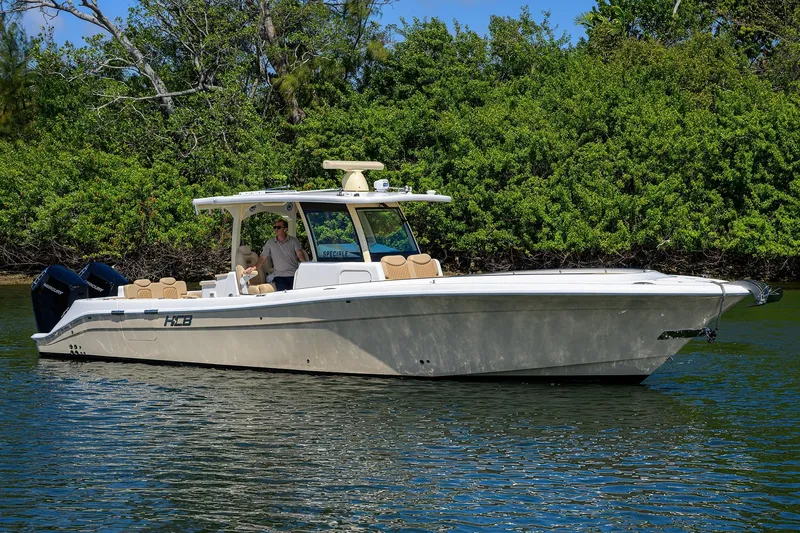 Slide: The Image of 2024 HCB 39 Speciale boat cruising on a calm waterway, surrounded by lush greenery. - 53