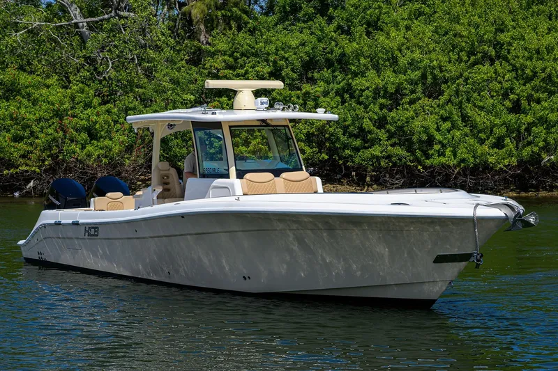 Slide: The Image of 2024 HCB 39 Speciale boat on water, surrounded by lush greenery. - 54