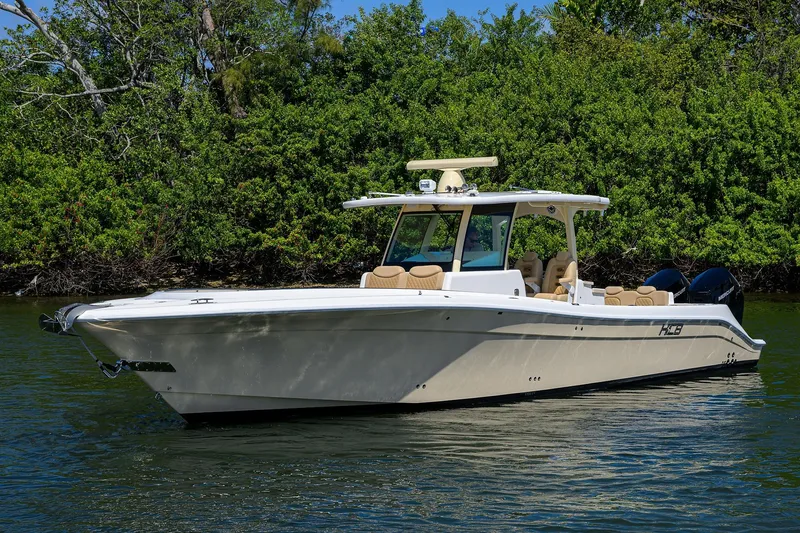 Slide: The Image of 2024 HCB 39 Speciale boat on calm water, surrounded by lush greenery. - 56