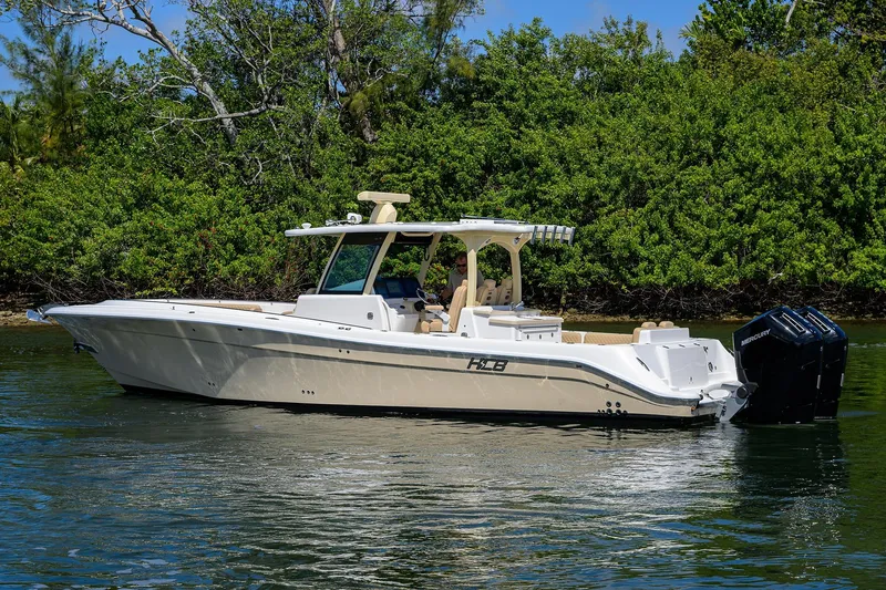 Slide: The Image of 2024 HCB 39 Speciale boat on calm water, surrounded by lush greenery. - 57