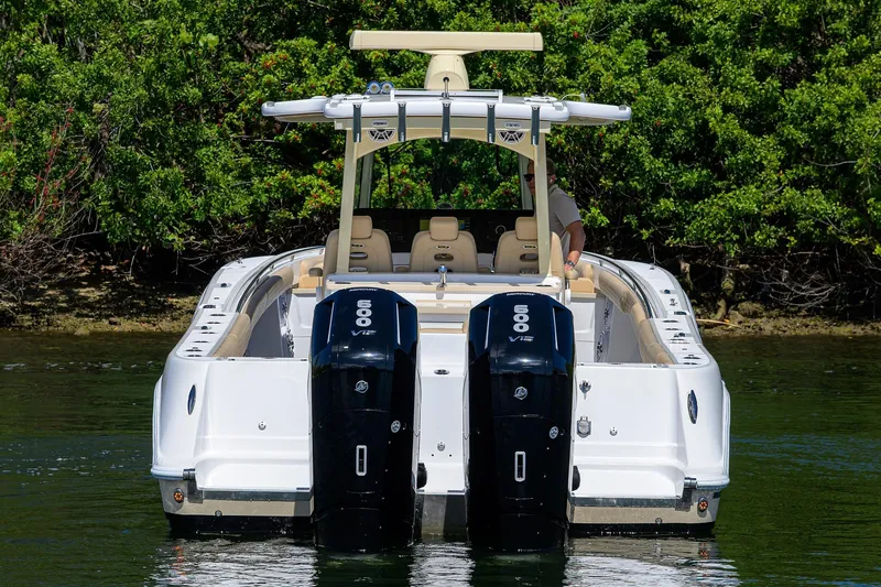 Slide: The Image of 2024 HCB 39 Speciale boat with dual 600 V12 engines, docked near lush greenery. - 59