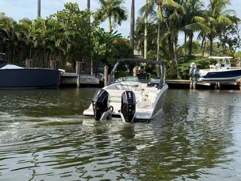 Slide: The Image of A 2026 Sea Ray SDX 290 Outboard navigates a calm waterway, surrounded by palm trees. - 12